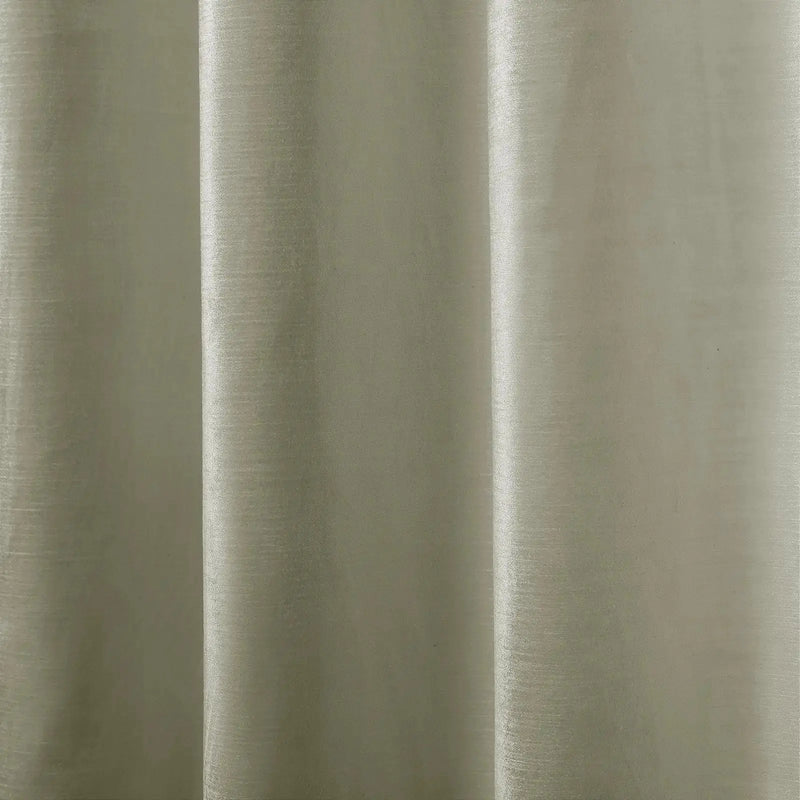 Close-up photograph of a light greige textile featuring a subtle textured weave and soft vertical drapes creating gentle highlights and shadows
