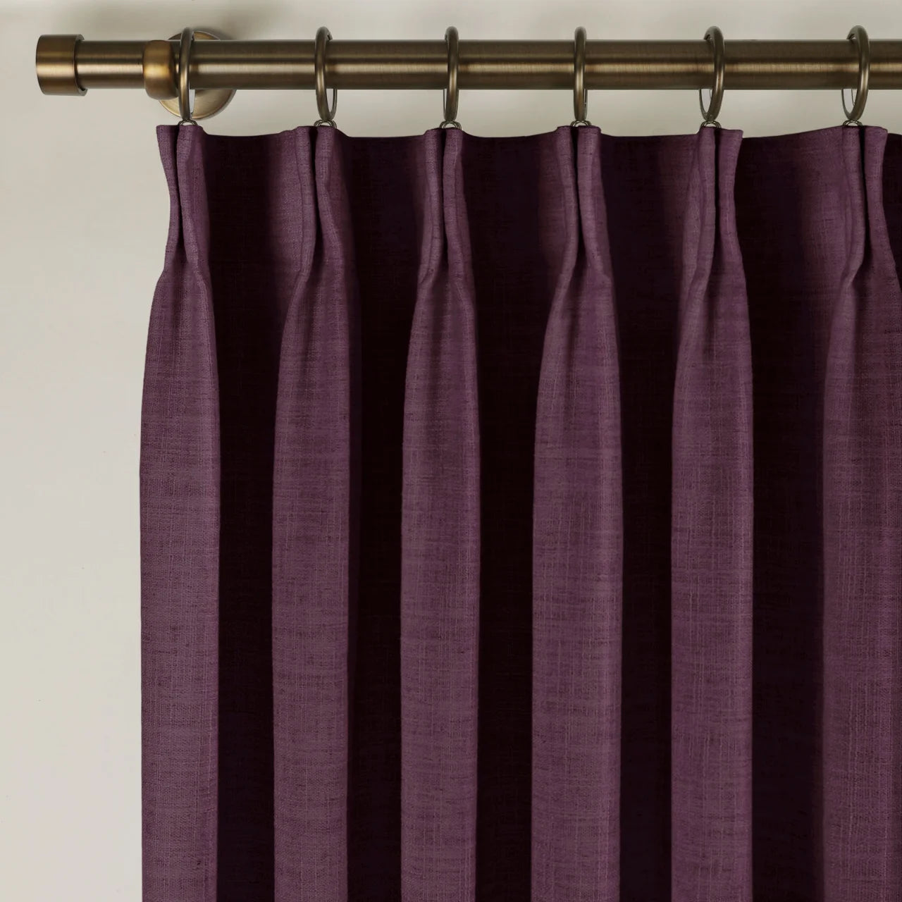 Plum Liz linen curtains viewed at an angle in a softly styled room with natural daylight