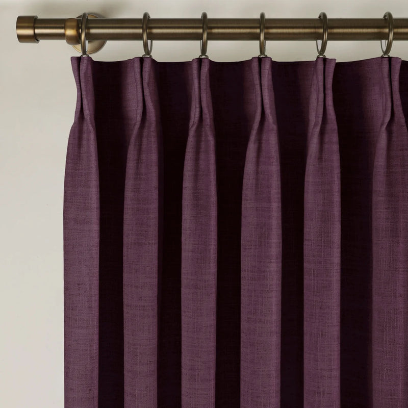Plum Liz linen curtains viewed at an angle in a softly styled room with natural daylight