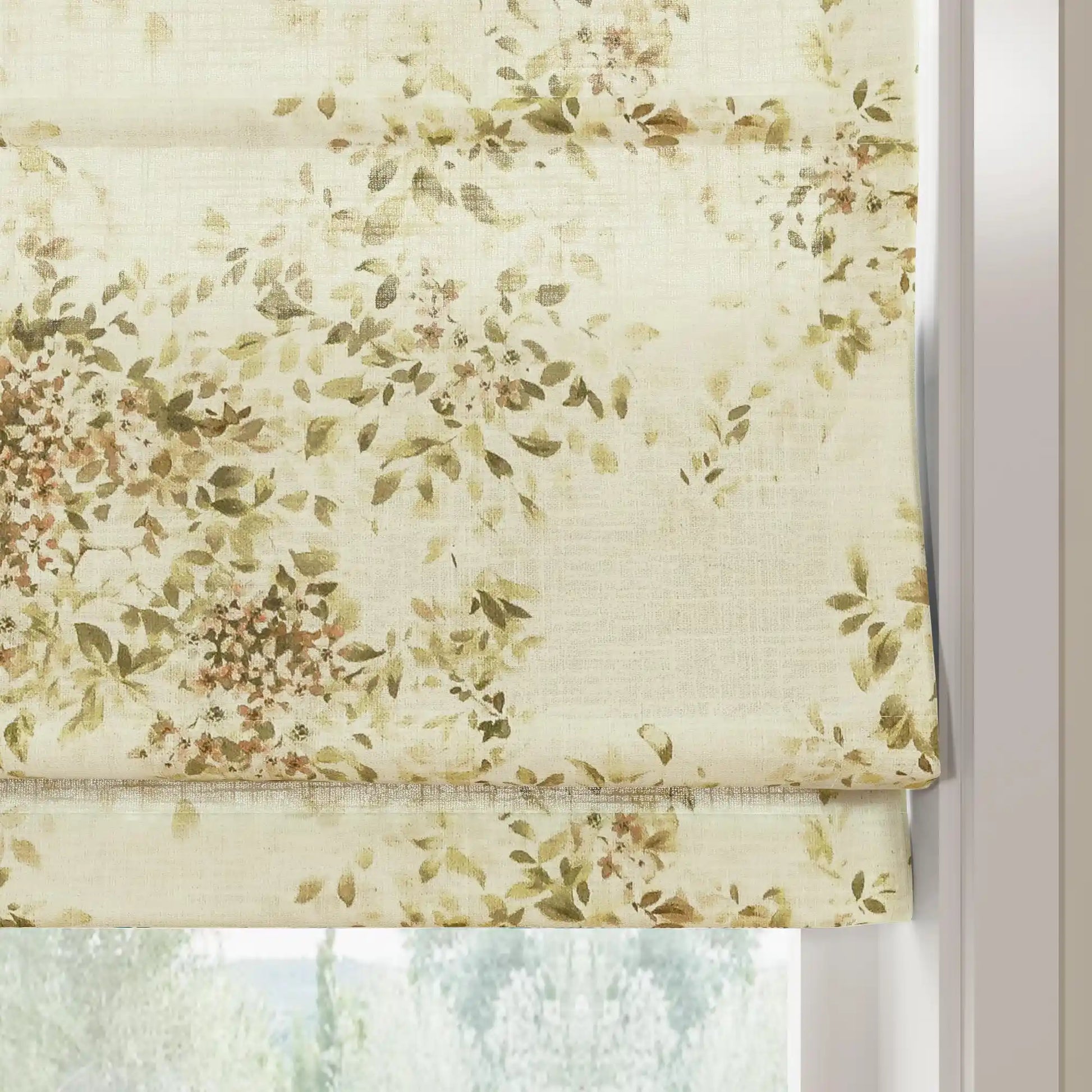 Fabric Roman blind with a watercolor botanical pattern featuring sage green leaves and soft brown blossoms on textured cream fabric partially covering a bright window