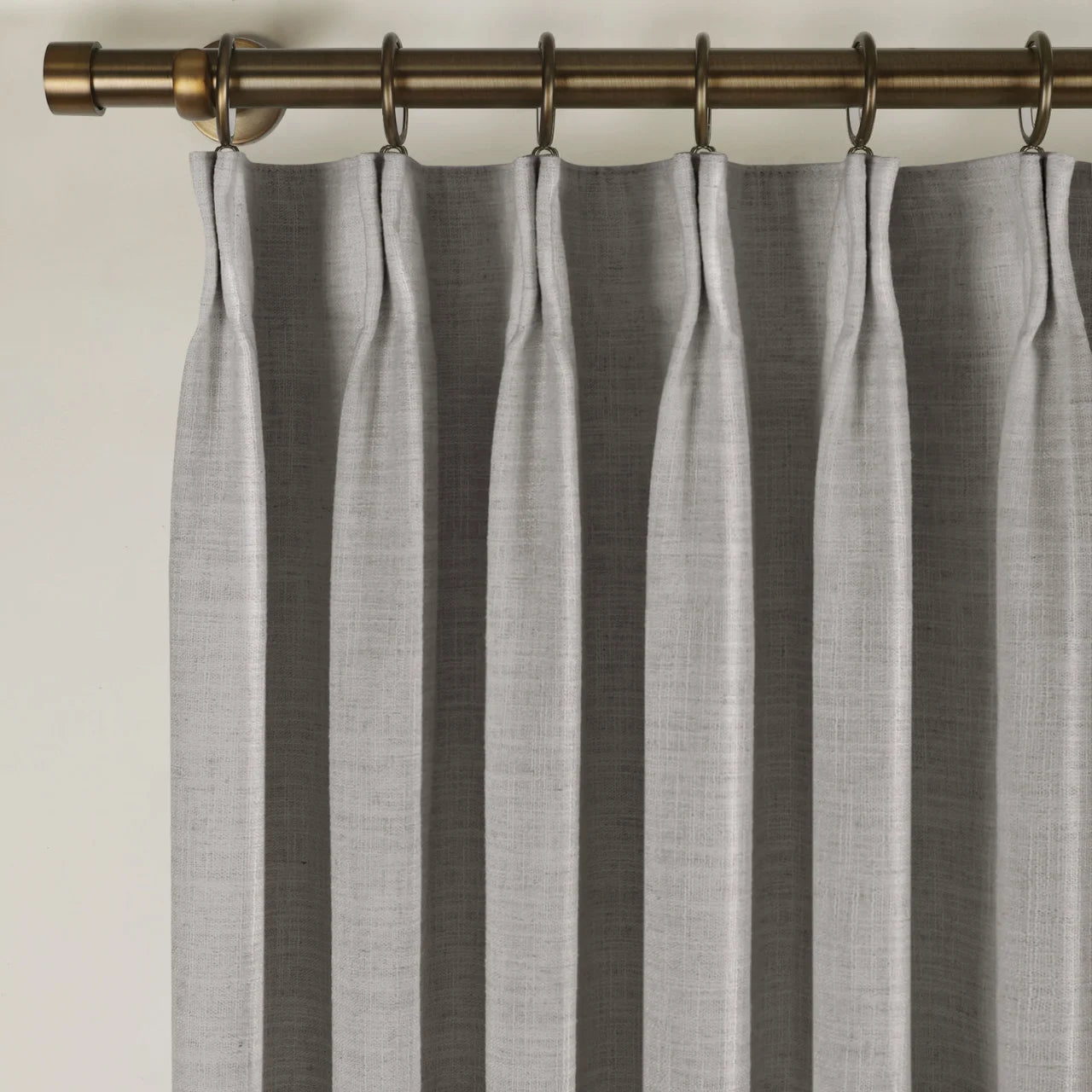 Rock Grey Liz linen curtains viewed at an angle in a softly styled room with natural daylight