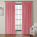 Bubblegum pink velvet curtains framing a black grid-pane window in an interior room featuring abstract gray and white tree artwork and a light gray armchair with a white fringed throw blanket