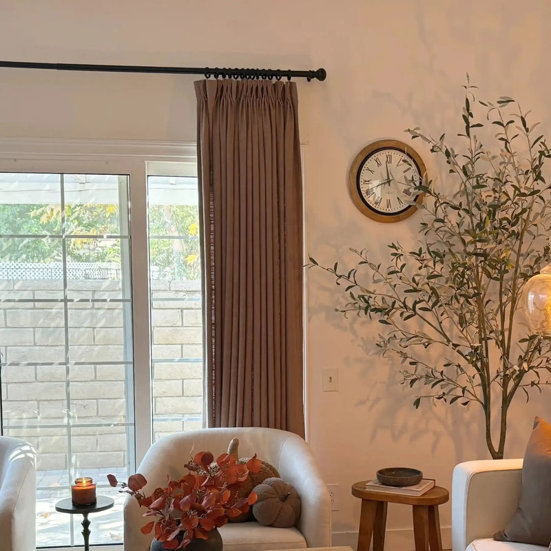 Rust Brown Liz Linen Pleated Curtains in a warm reading nook with an armchair, wall clock and olive tree