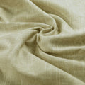 Photograph of textured olive beige fabric artfully draped into deep swirling folds revealing its subtle weave and nubbly surface