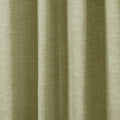 Close-up photograph of a textured sage green fabric curtain featuring prominent vertical pleats and a visible woven linen-like texture