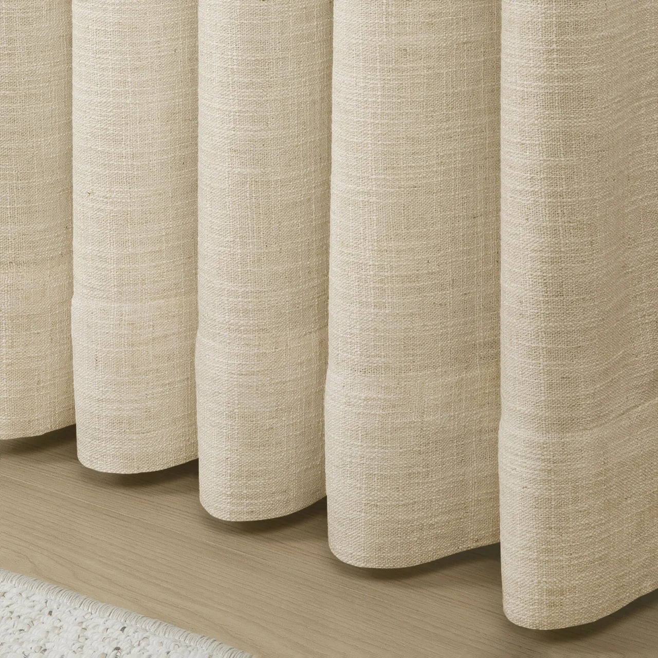 Sand Beige Liz Linen Pleated Curtains rounded curtain hems above a pale wood floor