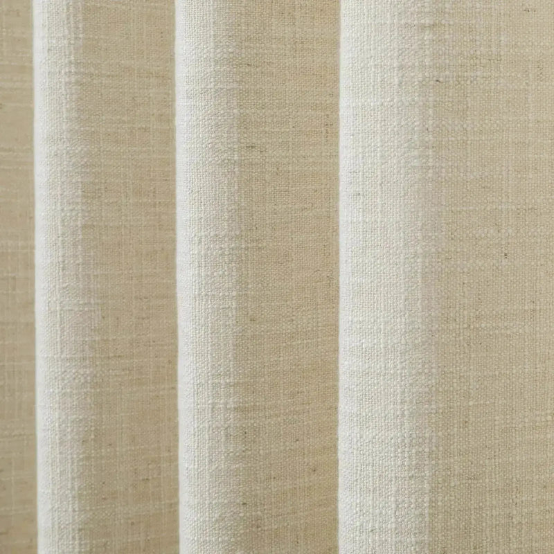 Close-up of oatmeal colored fabric with a coarse woven texture draped in soft vertical folds