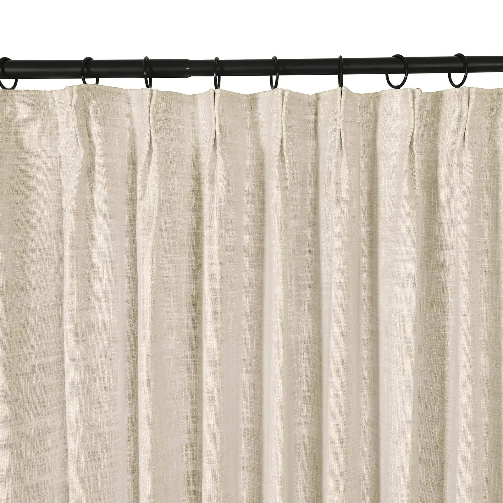 Photograph of a light beige curtain with a subtle linen texture hanging in neat pleats from a black curtain rod with dark rings