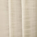 Photograph of light beige textured woven fabric draping in soft vertical folds with a subtle grid weave visible