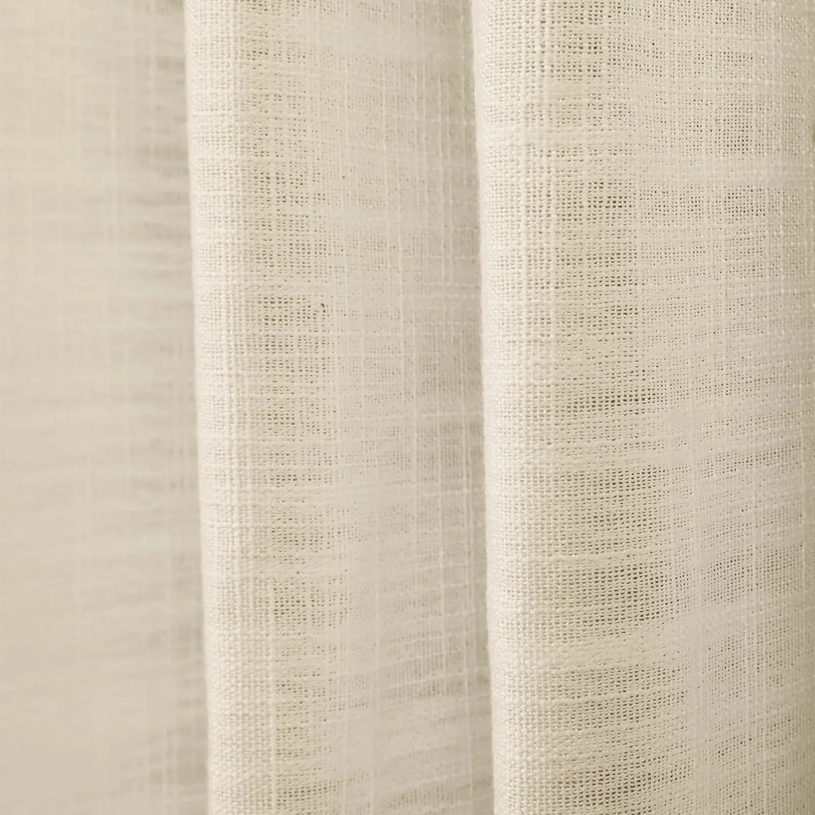 Photograph of light beige textured woven fabric draping in soft vertical folds with a subtle grid weave visible