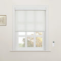 Photograph of a white six-pane window featuring white cordless cellular Blinds and a wall-mounted remote control, with a framed botanical print on the wall and autumn trees visible outside
