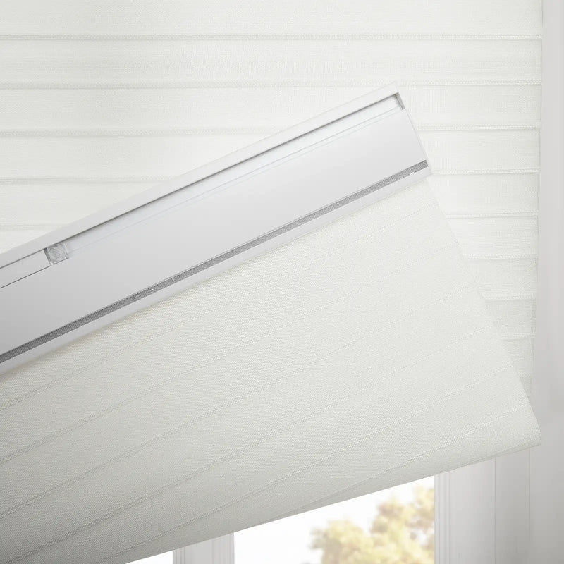 White layered window Blinds with a textured horizontal stripe pattern featuring a visible white headrail with a silver accent partially lowered to reveal outdoor foliage