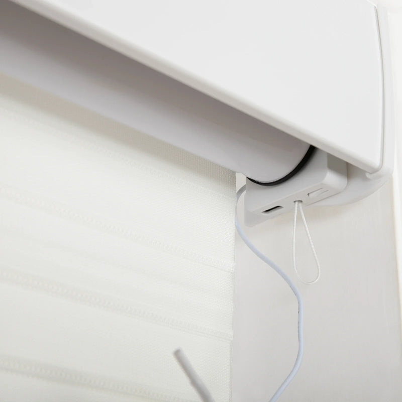 Close-up of a white motorized window Blind mechanism with a sheer fabric Blind featuring subtle horizontal textured bands, showing a white power cable connected to the housing and a small white pull cord loop