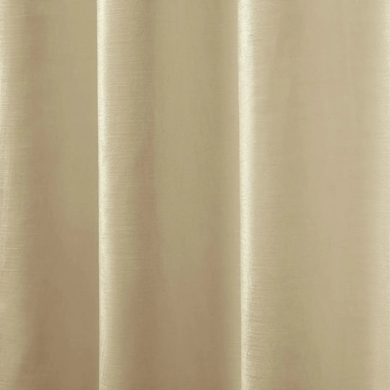 Photograph of a cream-colored fabric curtain with vertical pleats creating gentle shadows and highlights showcasing a subtle woven texture