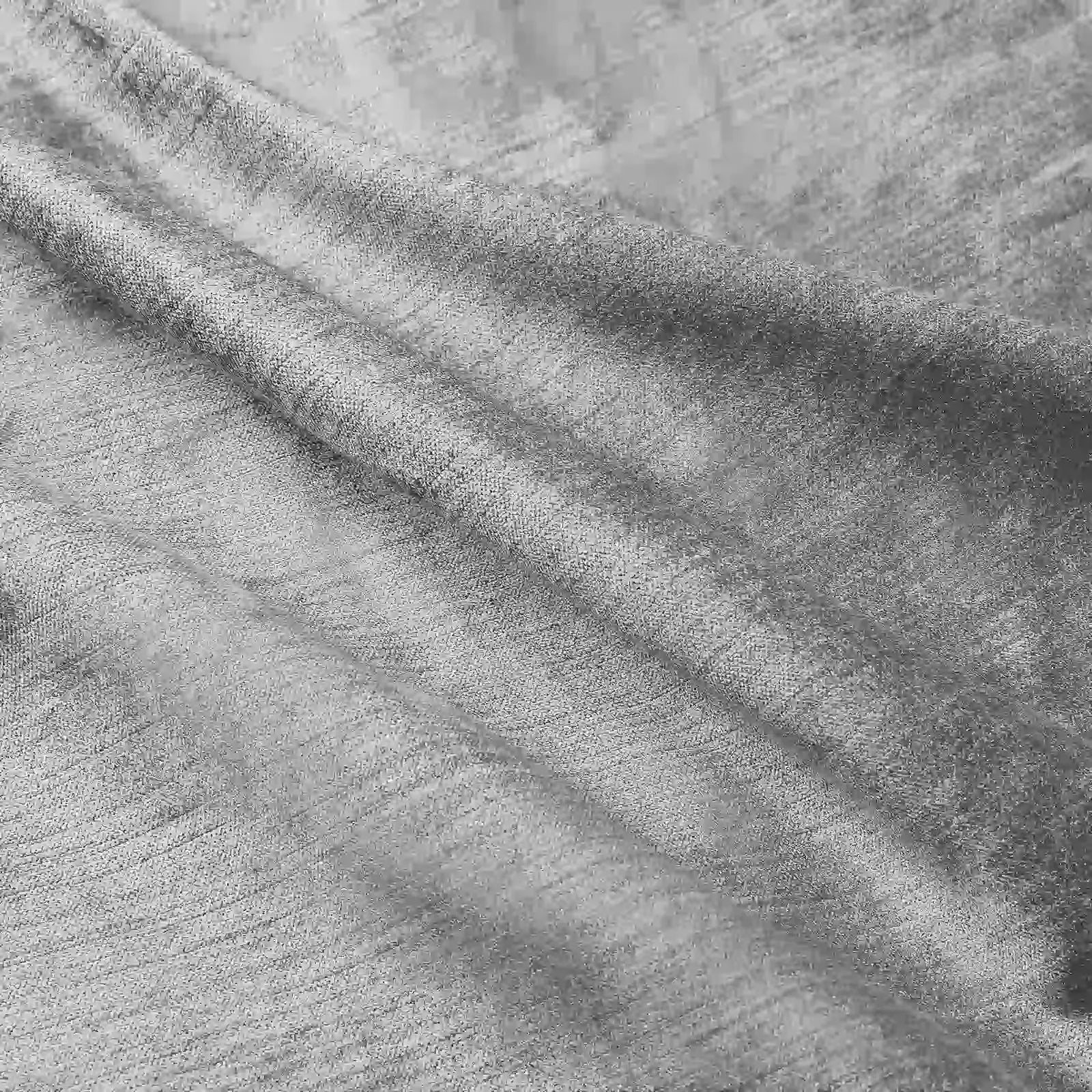 Photograph of grey textured fabric with soft folds and shadows