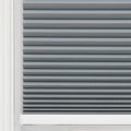 Grey cellular window Blind featuring neat horizontal pleats, textured fabric, a white window frame edge, and a white bottom rail