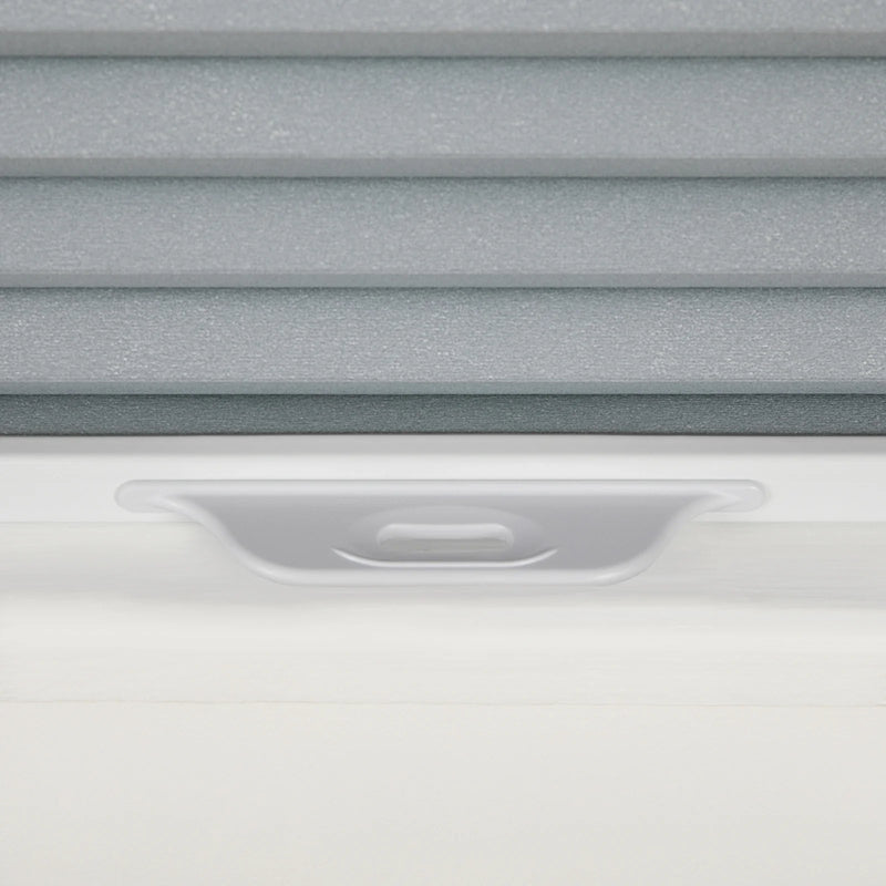 Close-up of gray textured cellular pleated window Blinds with a white frame and an integrated gray adjustment handle