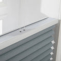 Photograph of modern cellular window Blinds in an interior setting featuring textured grayish-blue fabric a sleek white top rail and thin control cords