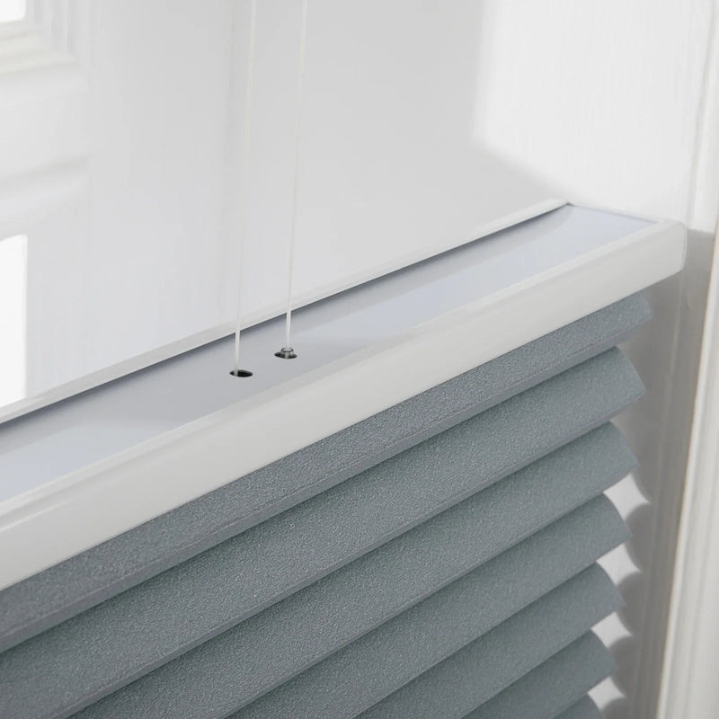 Photograph of modern cellular window Blinds in an interior setting featuring textured grayish-blue fabric a sleek white top rail and thin control cords