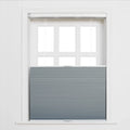 Digital photograph of a white-framed six-pane window partially covered by gray pleated cellular Blinds with a top-down bottom-up design against a white wall