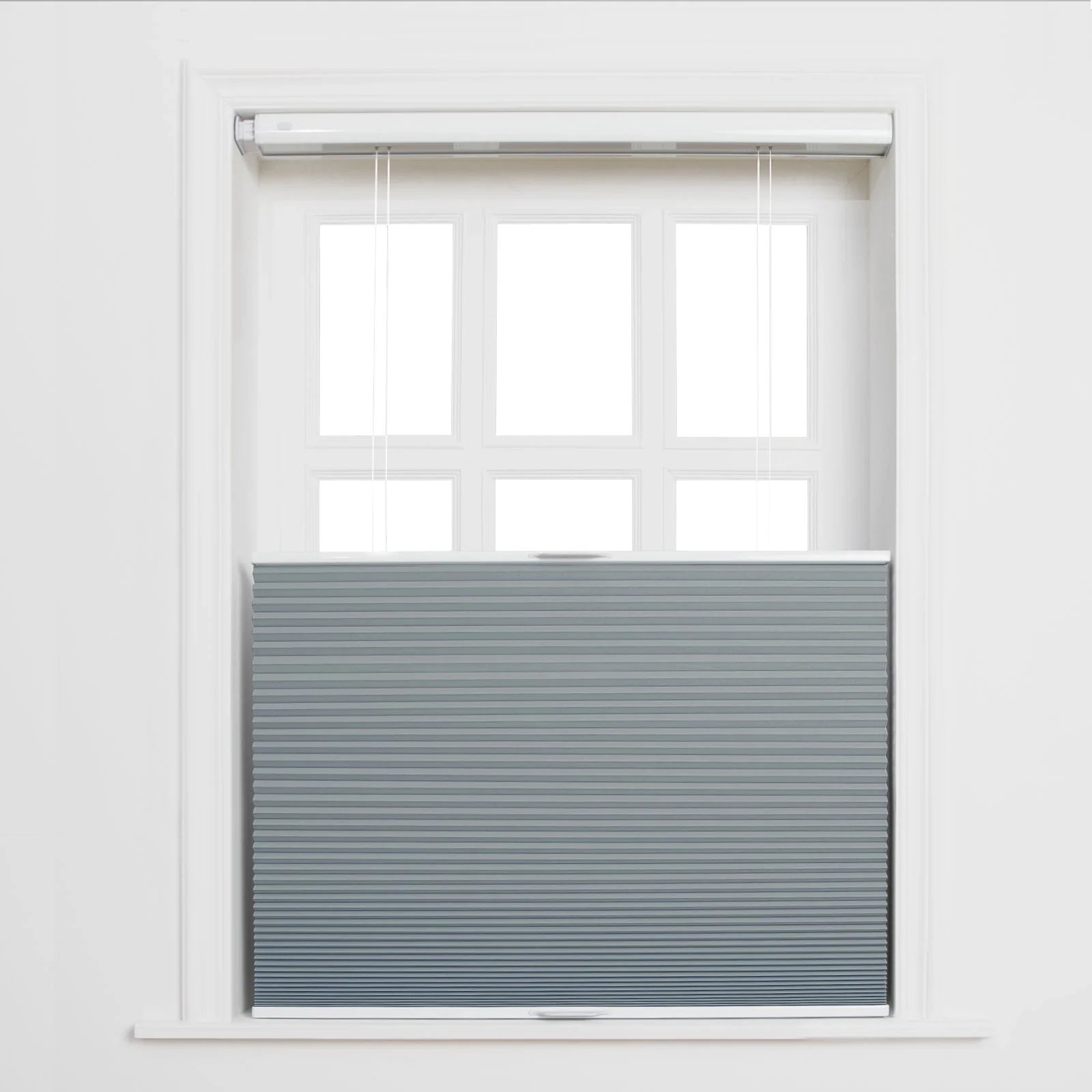 Digital photograph of a white-framed six-pane window partially covered by gray pleated cellular Blinds with a top-down bottom-up design against a white wall