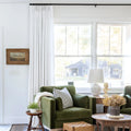 Snow White Liz Linen Pleated Curtains beside a green sofa and dried-flower coffee-table arrangement