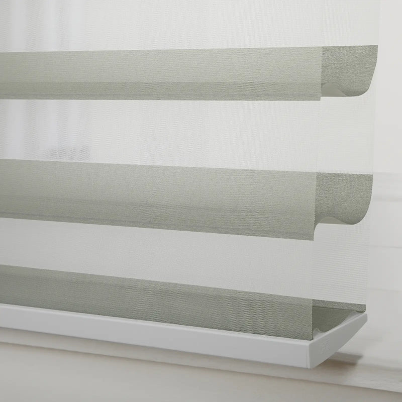 Textured light grey and white zebra Blind with alternating opaque and sheer horizontal stripes installed in a window