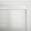 A white roller window Blind featuring alternating sheer and opaque horizontal stripes within a decorative white window frame, accented by a white pull cord with a small yellow bead