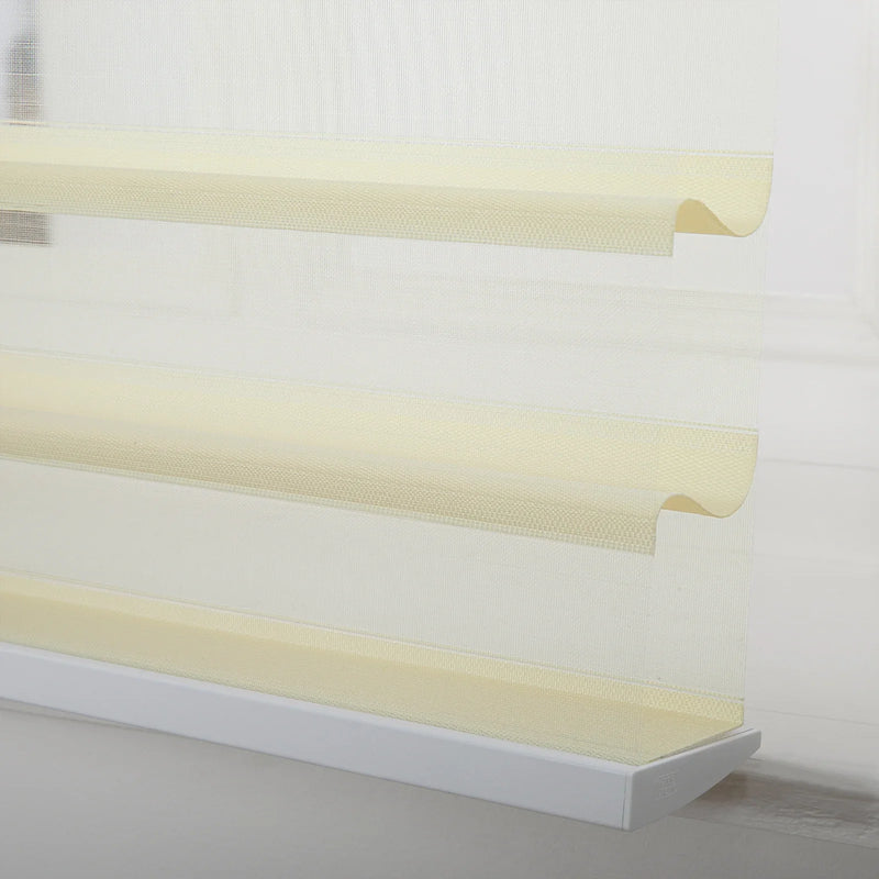 A modern zebra roller Blind featuring alternating sheer white and opaque beige horizontal stripes, a subtle woven texture, and softly curved fabric layers near the bottom