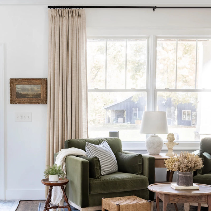 Tapioca Liz Linen Pleated Curtains beside a green sofa and dried-flower coffee-table arrangement