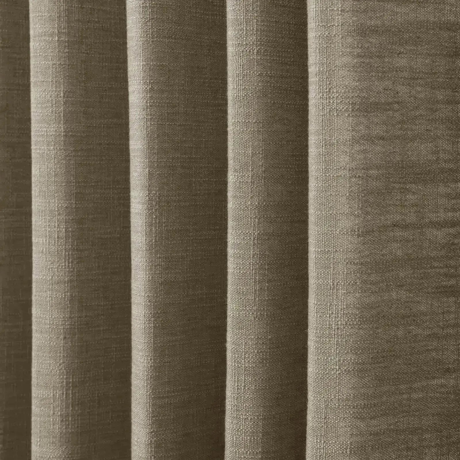 Close-up of a warm taupe textured fabric showing distinct vertical folds and a visible slub weave