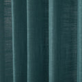 A close-up of deep teal fabric curtains featuring prominent vertical folds and a visible woven texture