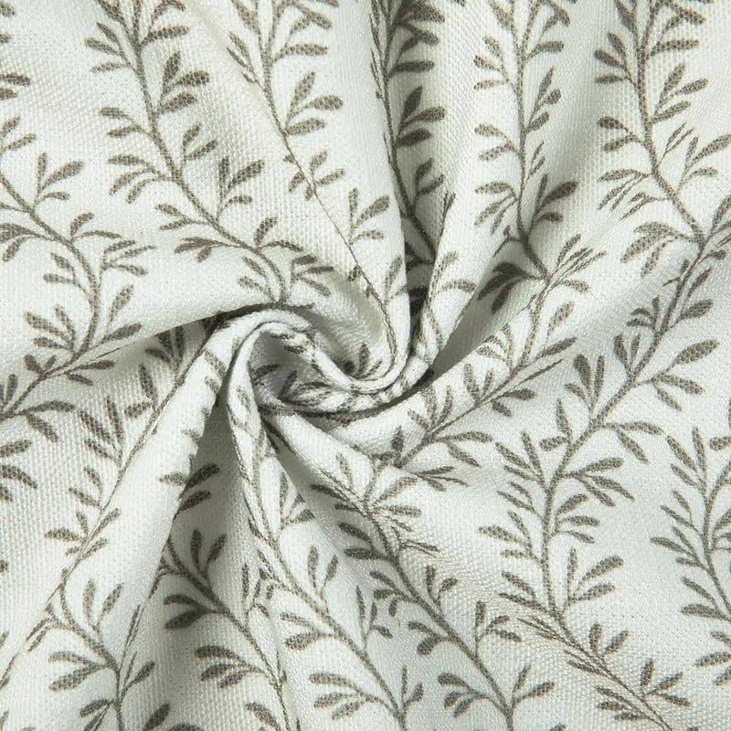 Textile featuring a white woven background with a repeating pattern of slender grey stylized leaves and branches, showing soft ripples and a central spiral fold highlighting its texture