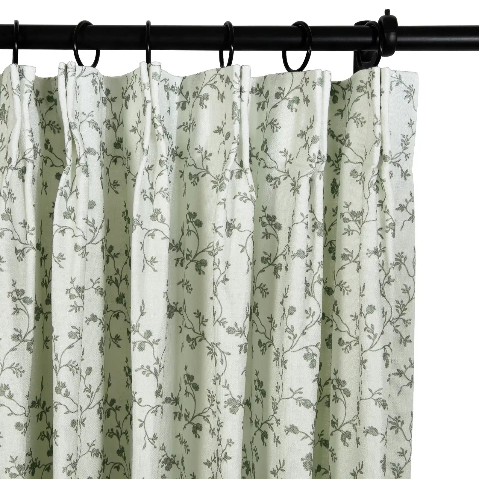 Light green pleated curtains featuring a delicate gray floral vine pattern suspended from a black curtain rod and rings