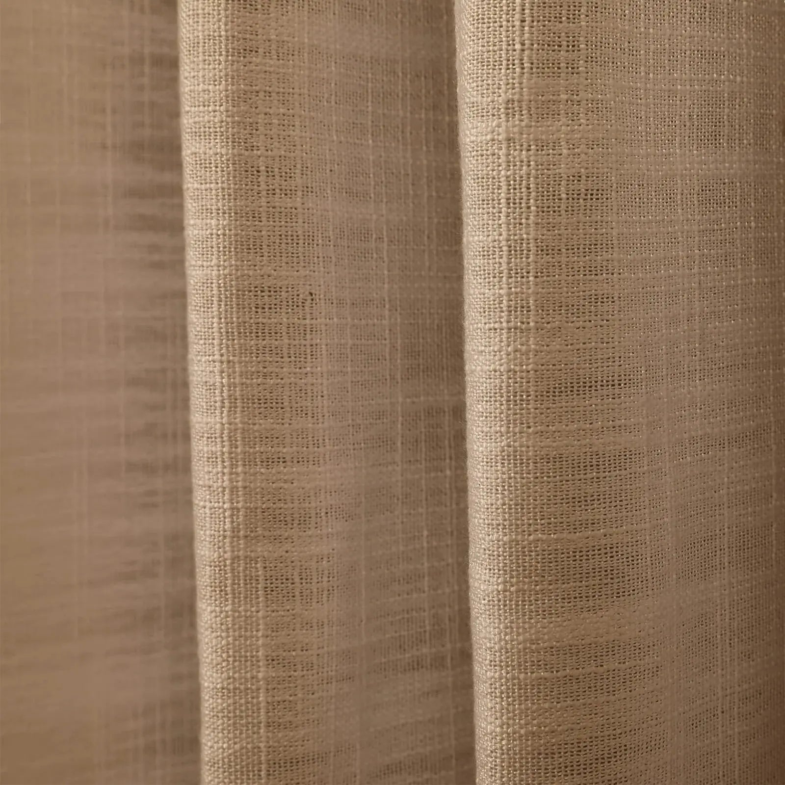 A light beige textured woven fabric curtain with prominent vertical folds and a distinct grid-like weave