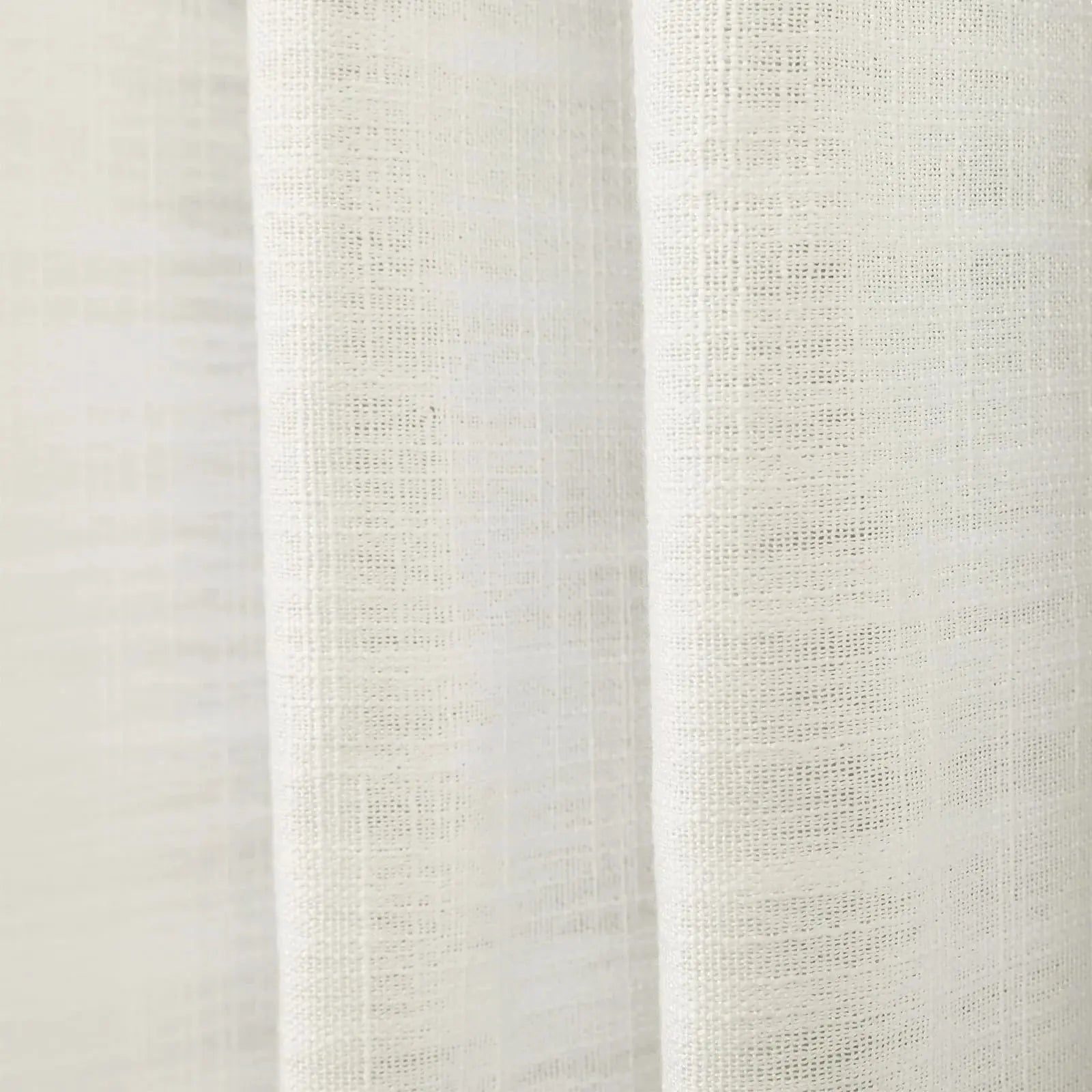 Photograph of a cream-colored sheer woven fabric showing a subtle grid texture and gentle vertical drapes