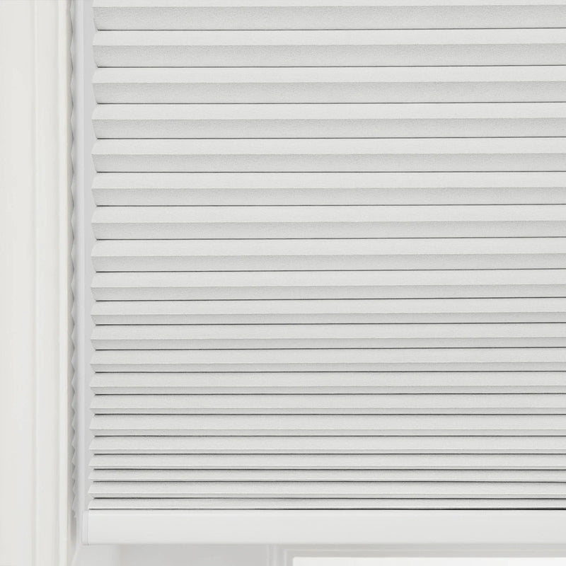Photograph of light gray pleated cellular window Blinds covering a window, showcasing their textured fabric and horizontal folds