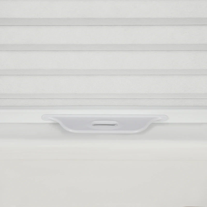 Detailed photograph of a white pleated cellular window Blind showcasing its subtle fabric texture and an integrated light grey plastic bottom rail handle for cordless operation