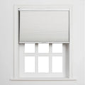 A modern interior features a partially lowered white cellular window Blind above a six-pane white window frame and sill against a minimalist white wall