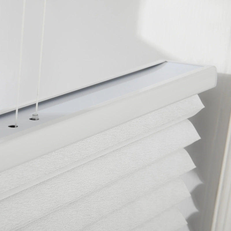 Close-up of white textured honeycomb cellular Blinds featuring a visible headrail with thin white adjustment cords and soft pleated fabric illuminated by natural light