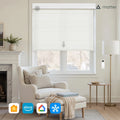 Elegant modern living room featuring a white cordless Roman Blind with remote control, a cream upholstered wingback armchair and ottoman with a cozy knitted throw, and a marble fireplace with a brass floor lamp