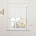 White cordless Roman Blind partially lowered on a multi-pane window in a modern home, flanked by a subtle botanical art print and a sleek wall-mounted remote control, revealing colorful autumn trees outside