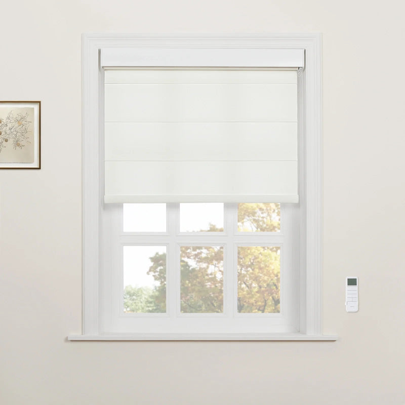 White cordless Roman Blind partially lowered on a multi-pane window in a modern home, flanked by a subtle botanical art print and a sleek wall-mounted remote control, revealing colorful autumn trees outside