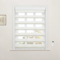White zebra Blinds covering a window in a modern room with a remote control on the wall and a framed botanical print nearby