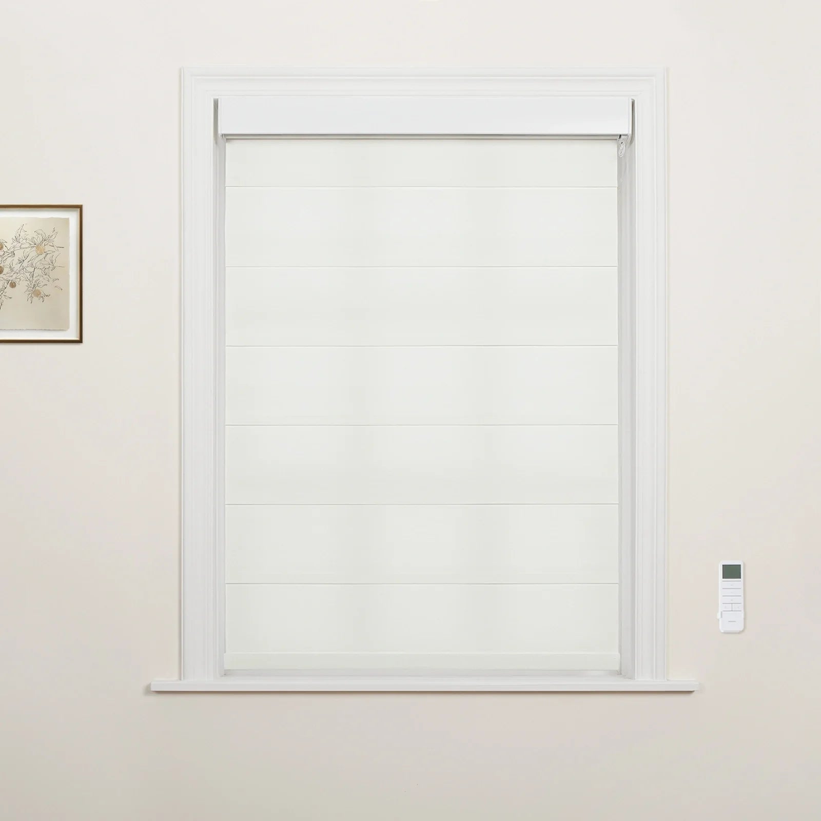 Photograph of an interior window featuring white tiered Roman Blinds, white decorative trim, a subtle framed botanical print to the left, and a white wall-mounted remote control to the right