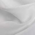 Photograph of elegant white fabric draped in soft flowing folds with subtle shadows highlighting its delicate texture