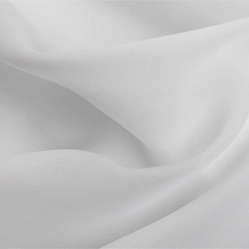 Photograph of elegant white fabric draped in soft flowing folds with subtle shadows highlighting its delicate texture