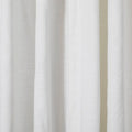 Close-up of white linen curtains showcasing a subtle woven texture soft vertical folds and gentle ambient lighting