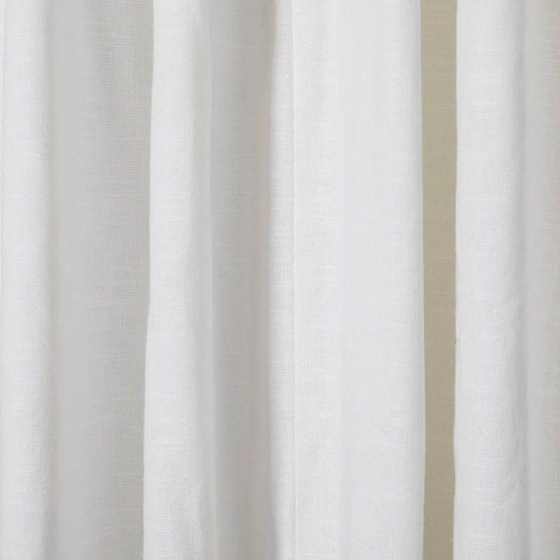 Close-up of white linen curtains showcasing a subtle woven texture soft vertical folds and gentle ambient lighting