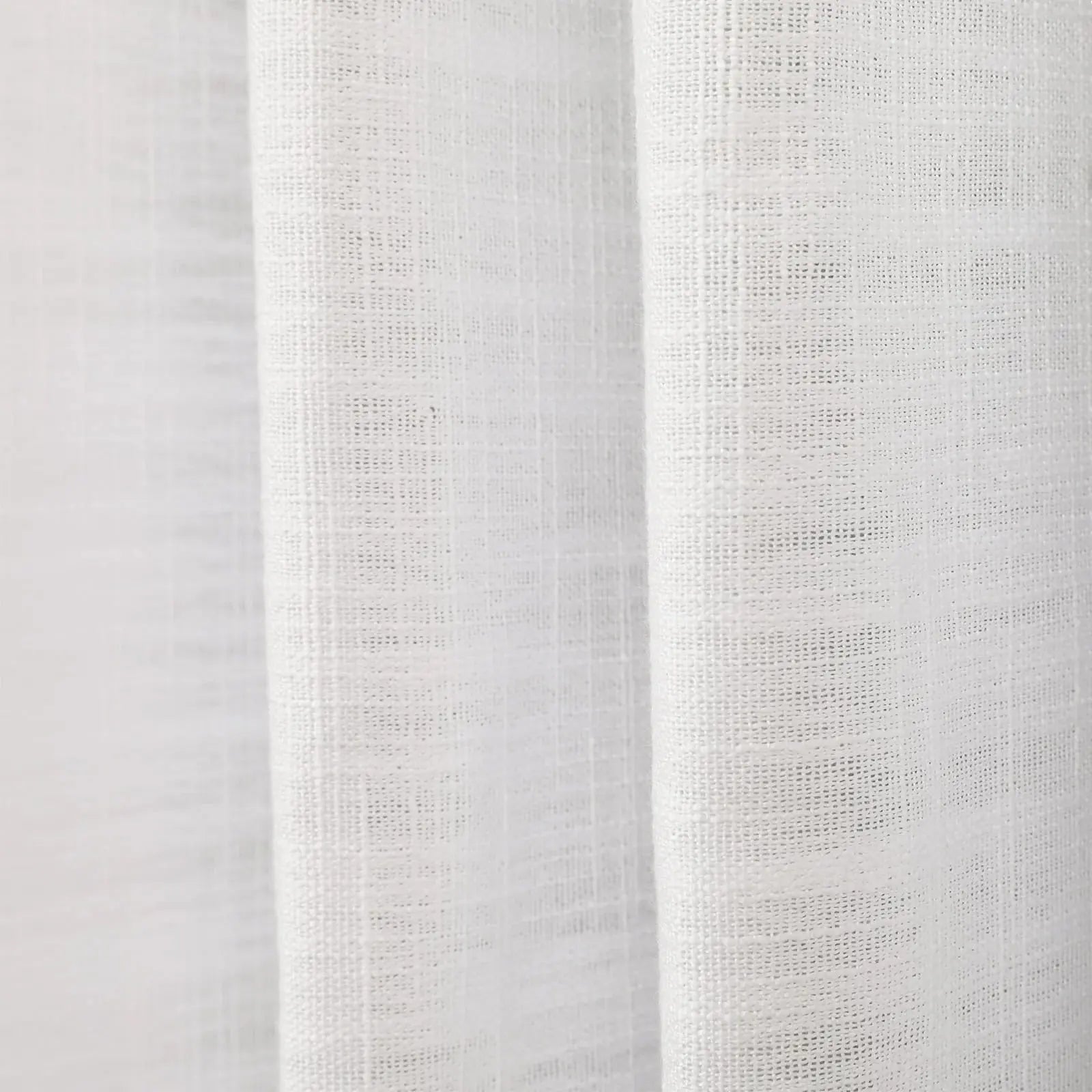 Photograph of white textured linen fabric showing distinct woven threads and soft vertical drapes creating subtle shadows